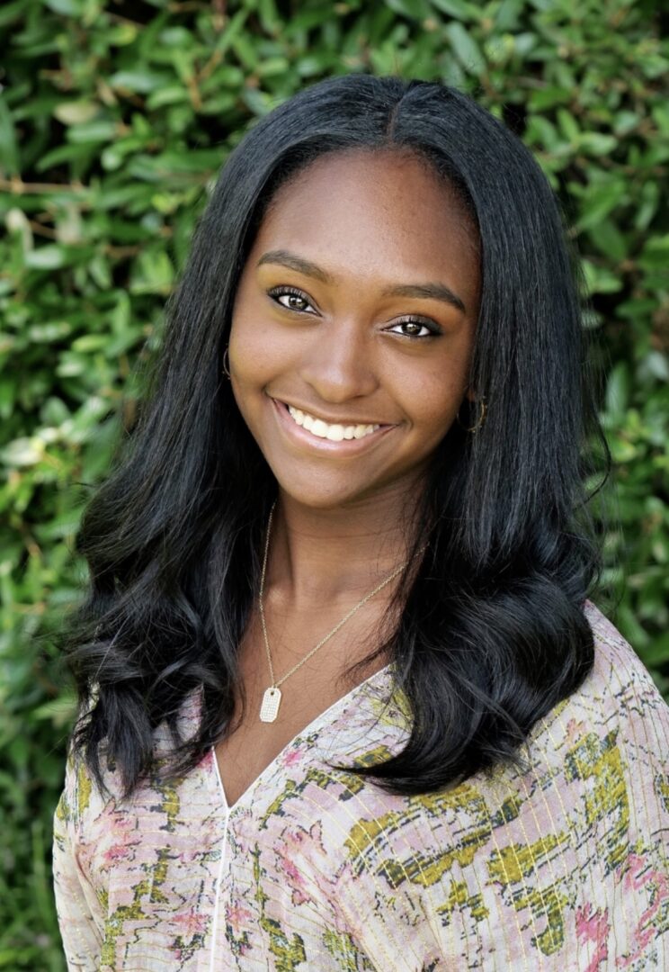 A woman with long black hair smiles for the camera.